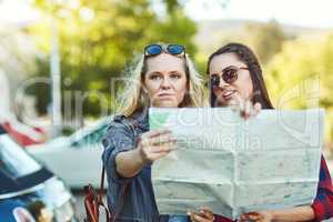 Getting lost is part of the journey. two beautiful female friends looking at a map for directions in the city.