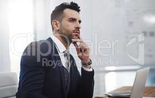 Once he dreams of a big plan, he executes it bigger. a young businessman looking thoughtful in an office.