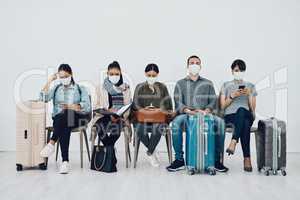 Travel and tourism during the pandemic with passengers wearing masks and being safe in an airport waiting line. Group of people in a departure lounge, ready to board and complying with covid protocol