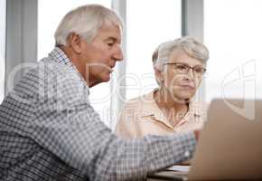 Financial planning is a team effort. a senior couple working on their finances at home.