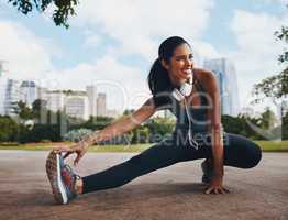 Smile your way to fitness. Full length shot of an attractive young sportswoman doing stretch exercises outdoors in the city.
