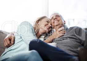 Sit back, relax and enjoy these leisurely years. a mature couple relaxing on the sofa together at home.
