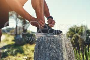 Secure and steady. an unrecognizable male runner tying his shoelaces outdoors.