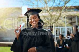 Smiles of educational success. Portrait of a happy young woman holding a diploma on graduation day.