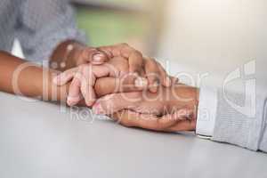 The company that promotes a culture of kindness. a businessman and businesswoman compassionately holding hands at a table.