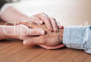 Nothing heals like the human touch. a man and woman holding hands in comfort on a table.