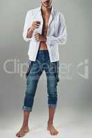 Know your style and wear it well. Studio shot of a handsome young man wearing jeans and a white shirt against a grey background.