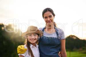 One day, thisll be all hers. Cropped portrait of an attractive young woman and her daughter standing on their family farm.