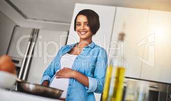 Time to fill mine and babys bellies. a pregnant young woman preparing a meal on the stove at home.