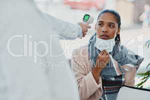 Covid temperature scanning a woman head at the border or an airport with real scared, concerned and serious expression on her face. Traveling refugee or foreign lady with a face mask in quarantine