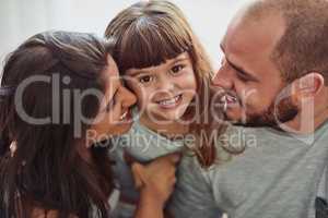 Mommy and daddy love me very much. Portrait of a mother and father bonding with their adorable young daughter at home.