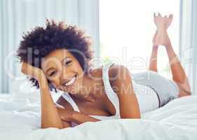 Relaxation at its best. an attractive young woman chilling on her bed at home.