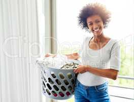 Beginning my day of daily chores. an attractive young woman holding a washing basket at home.