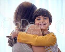 Mom calls me her little man. an adorable little boy affectionately hugging his mother at home.