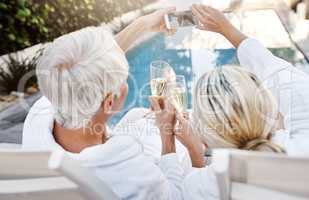 Look where we are everyone. Rearview shot of a cheerful middle aged couple having a celebratory toast with champagne outside during the day.