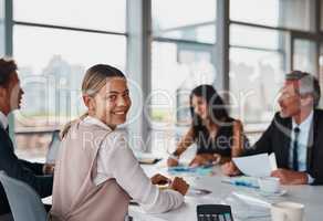 Brainstorming in the boardroom. corporate businesswoman looking back while in a meeting in the boardroom.