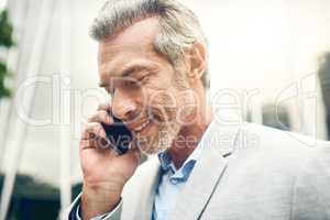 Ill be back in the office shortly. a mature businessman talking on a cellphone in the city.