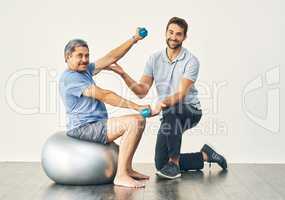 Hes making great progress. Full length portrait of a young male physiotherapist assisting a senior patient in recovery.