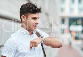 Chatting on a smartwatch with a young creative business man or intern commuting in the city. Hailing a cab, taxi or ride with an app on wireless technology. Male employee travelling to and from work