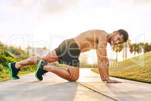 Steeping up his fitness game. Portrait of a handsome young man exercising outdoors.