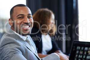 These meetings are always great. Cropped portrait of a handsome young businessman sitting in the boardroom during a meeting.