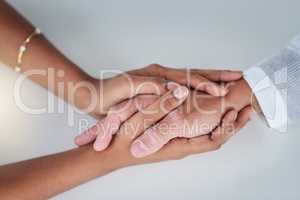 You can always count on me. a businessman and businesswoman compassionately holding hands at a table.