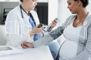 Everything seems to be normal. a confident female doctor checking the blood pressure of a pregnant patient at a hospital during the day.