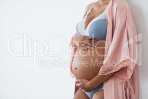 I cant wait to cuddle you. Studio shot of a pregnant young woman standing against a white background.