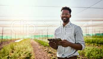 Young African male farmer working on healthy agriculture development strategy on his digital tablet. Smiling field worker outdoors on organic farming and growth sustainability check up