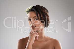 Beauty comes naturally to her. Studio portrait of a beautiful young woman with flowers in her hair posing against a gray background.