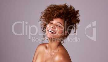 Less heat, more happy hair. Studio shot of a beautiful young woman posing against a pink background.