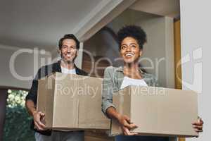 New house, moving and happy couple carrying boxes while feeling proud and excited about buying a house with a mortgage loan. Interracial husband and wife first time buyers unpacking in dream home