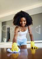 I love it when my counter shines. an attractive young woman wiping the kitchen counter at home.