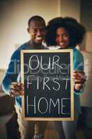 This is the new start weve been looking for. Portrait of a cheerful young couple holding up a sign saying our first home together while being surrounded by cardboard boxes inside at home.