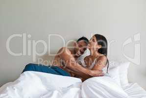 Some laughter with my lover. an affectionate young married couple in bed at home.