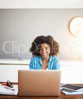 Im in the mood today to get some work done. an attractive young woman working on her laptop at home.