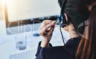 Managing the calls for the day. Rearview shot of a young woman working in a call centre.