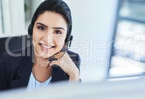 Ill be answering any queries you have. Portrait of a young woman working in a call centre.