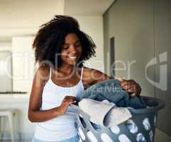 Keeping her home in order starting with laundry. an attractive young woman doing the laundry at home.