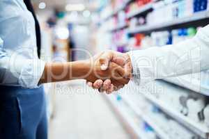 Customers keep coming back for our helpful service. Closeup shot of an unrecognizable pharmacist shaking hands with a customer in a chemist.
