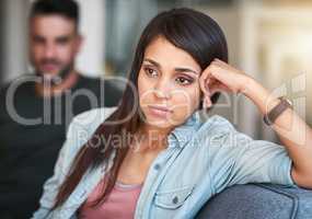 Why is our relationship filled with all this tension. a young woman looking upset after having a fight with her partner at home.