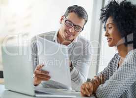 Our profits can go well beyond this. two businesspeople going through some paperwork in an office.