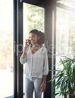 She takes the time to speak to her clients. a young businesswoman talking on a cellphone in an office.