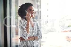 I like the sound of good news. a young businesswoman talking on a cellphone in an office.