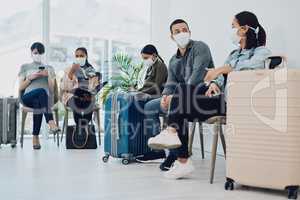 Group of people traveling during covid waiting in line at an airport lounge wearing protective masks. Tourists sitting in a queue at a public travel facility during coronavirus pandemic