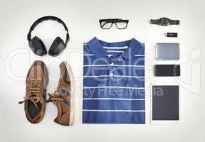 Flat lay of casual clothes, technology and shoes with a phone, tablet and headphones against background from above. All you need with a watch, USB stick and glasses for creative business workwear