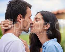 Kiss me like you miss me. an affectionate young couple kissing while standing outdoors.