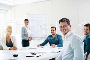 Success is exactly our thing around here. Portrait of a young businessman having a meeting with his colleagues in an office.