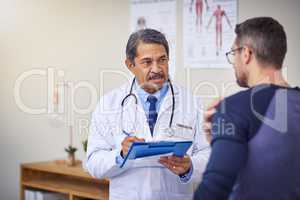 How long has this pain been present. a confident mature male doctor consulting a patient while standing inside a hospital during the day.