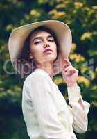 Her beauty is completely mesmerizing. Portrait of an attractive young woman wearing a stylish hat outdoors.